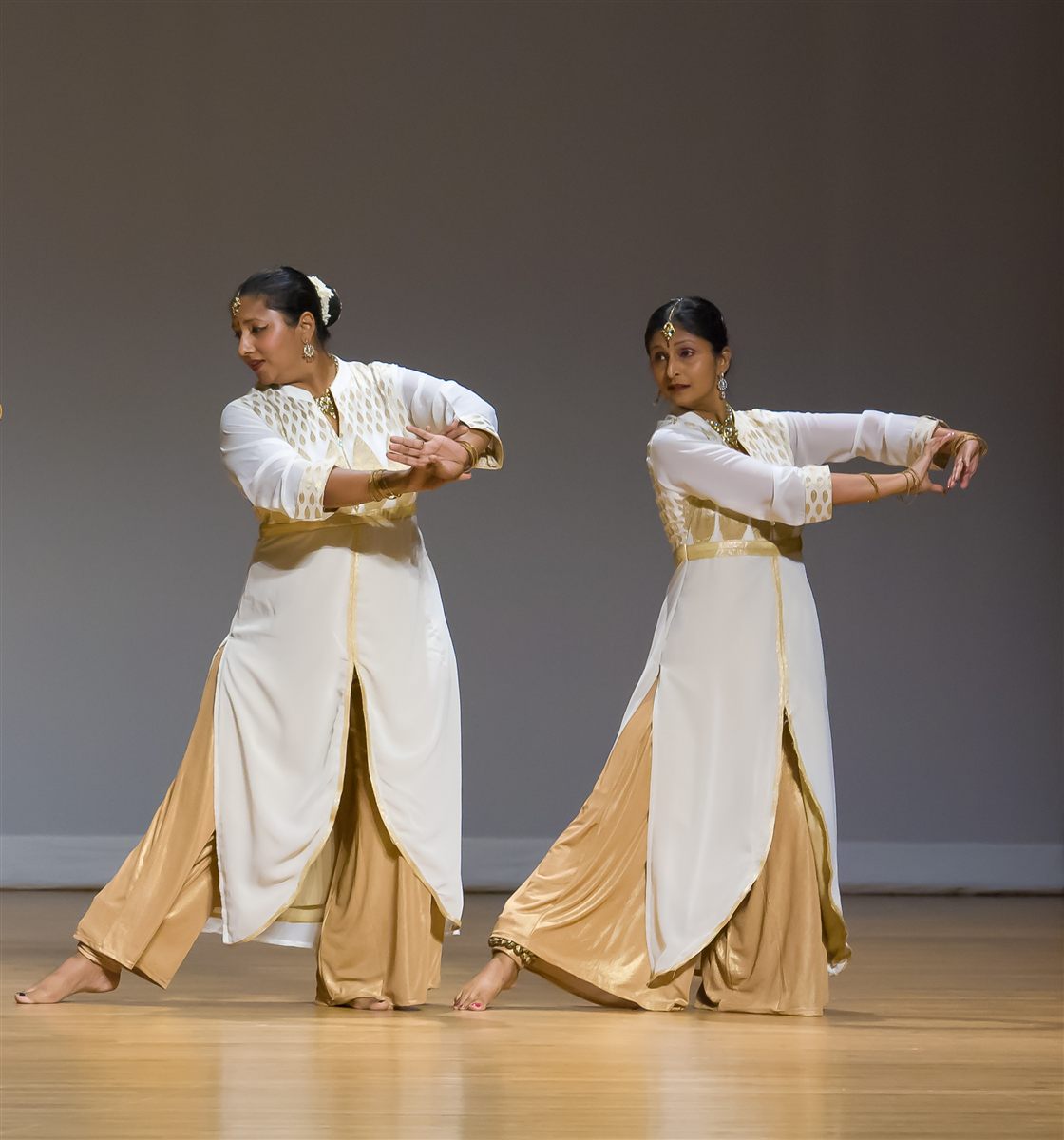 Aarti Gupta and Sapna Adhikari in expressive Kathak poses in white and gold classical attire