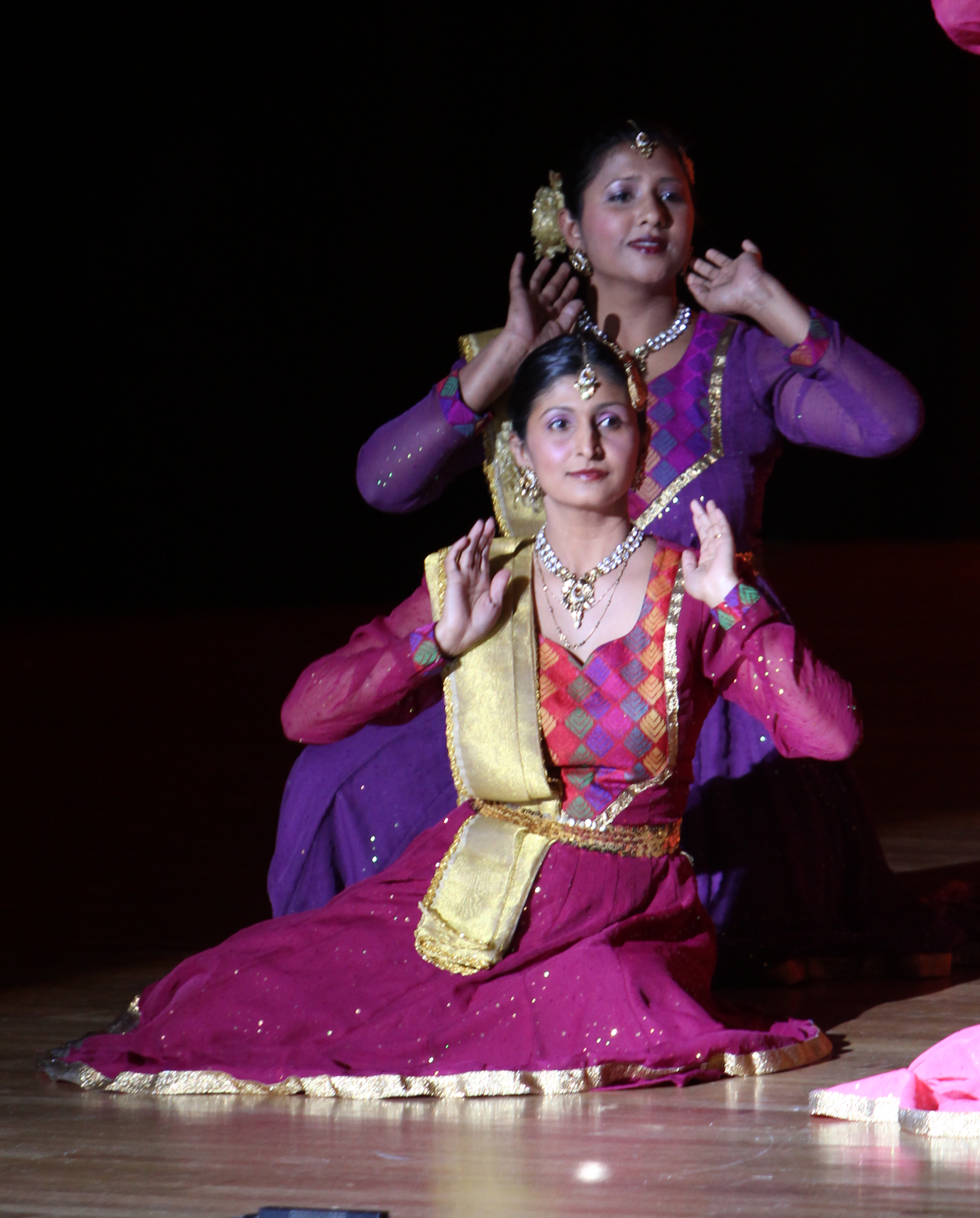 Aarti Gupta and Sapna Adhikari performing Kathak on stage in purple and magenta lehengas